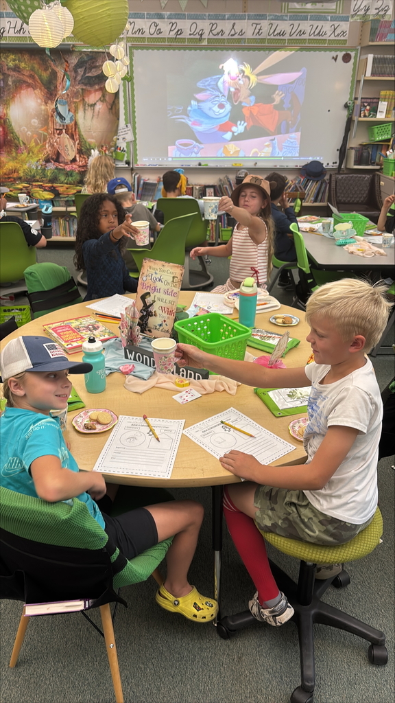 Students enjoy a tea party in a classroom.