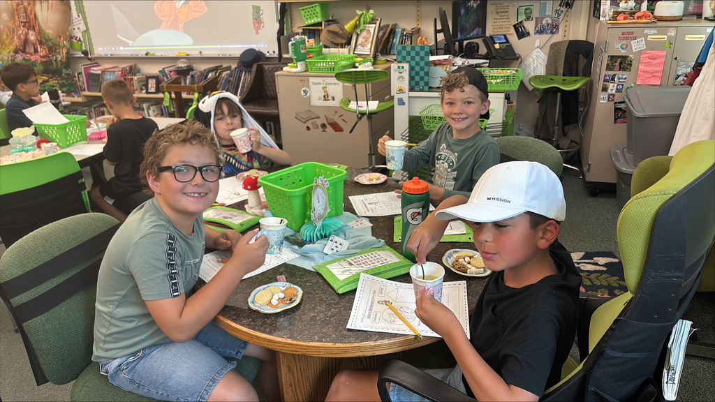 Students enjoy a tea party in a classroom.