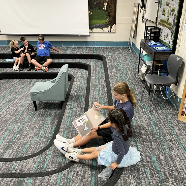 Many students can be seen reading together and smiling in the library.