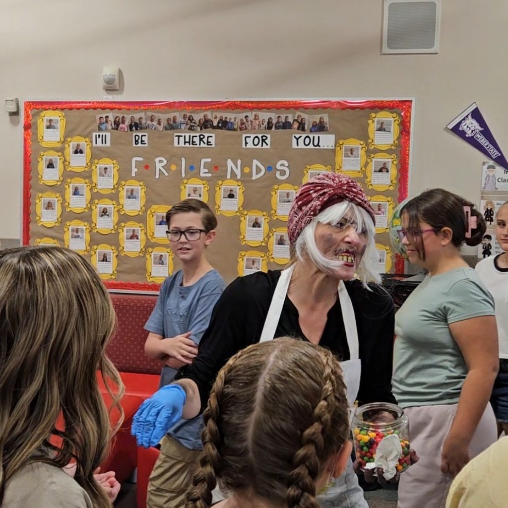 Mrs. Pratchett hand candy out to students.