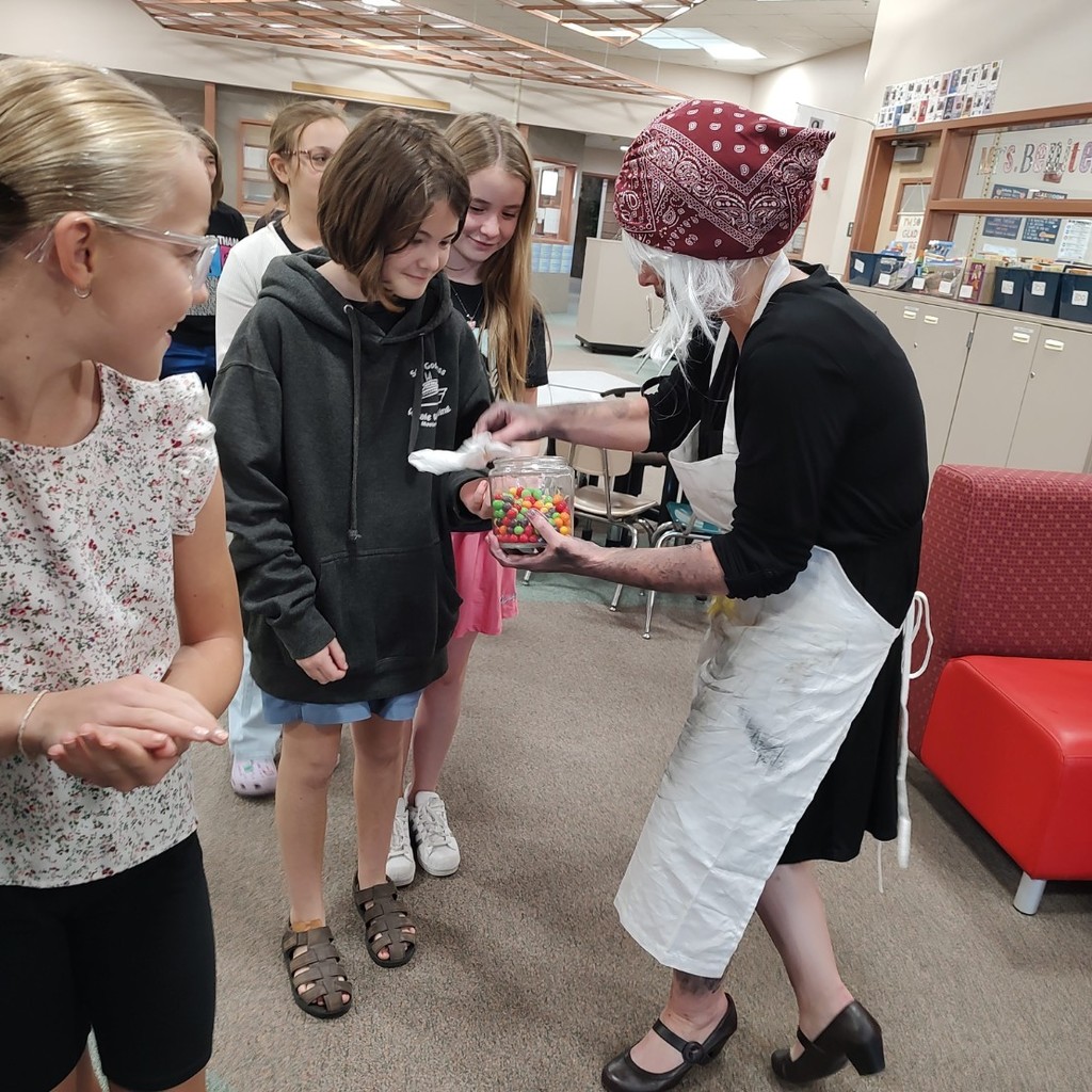 Mrs. Pratchett hand candy out to students.