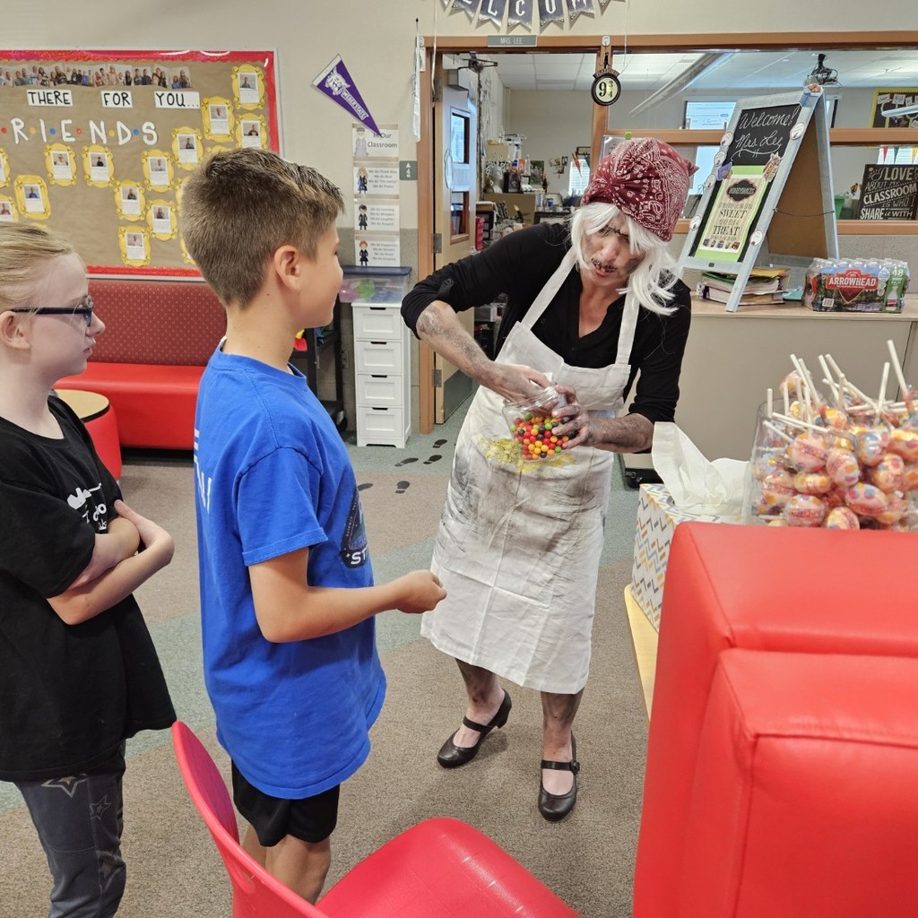 Mrs. Pratchett hand candy out to students.