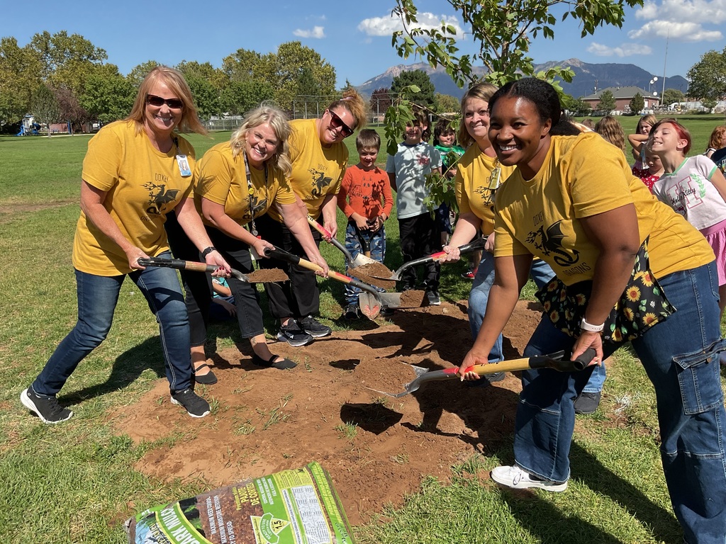 5 Teachers standing and posing with shovels full of dirt.