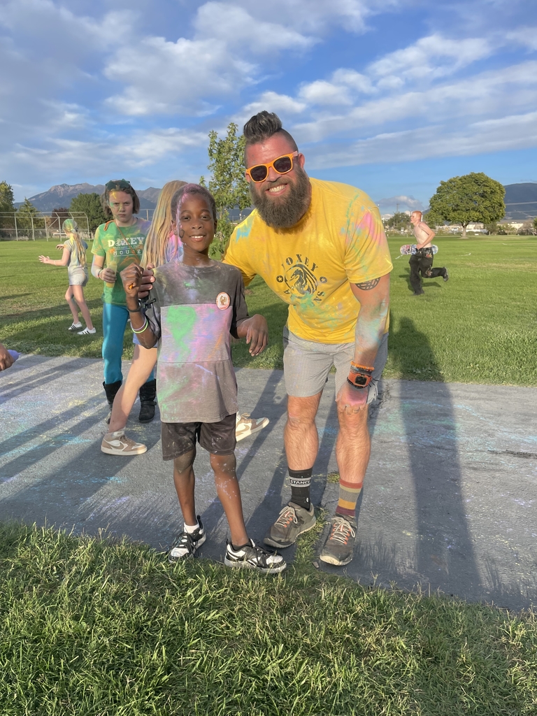 Principal Hansen posing with his son covered in chalk dust after participating in the chalk run