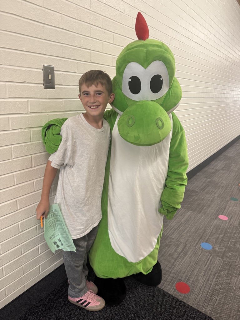 Student posing with Doxey's mascot Dexter for the schools scavanger hunt.