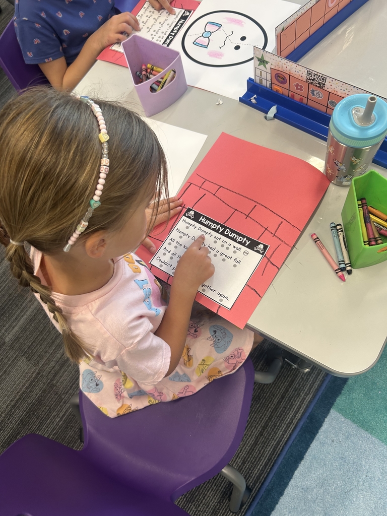 girl sitting at desk reading the humpty dumpty rhyme