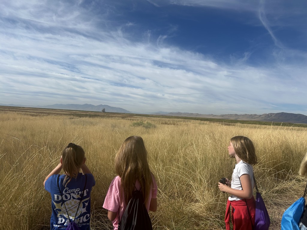 3 girls using binoculars to look over the wetland