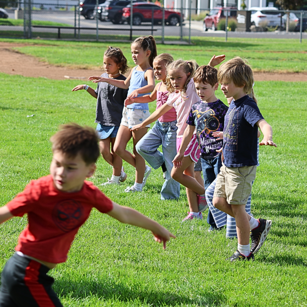 A row of students jumping on one foot.