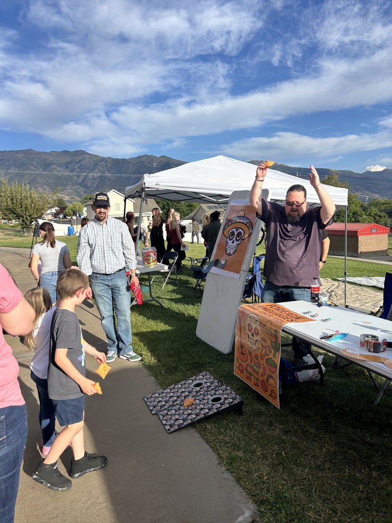 Spanish teachers celebrate after a child plays cornhole.