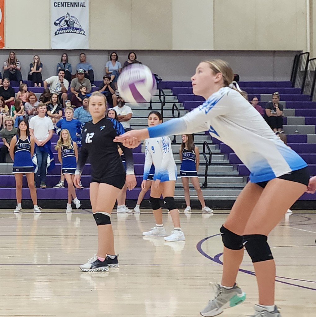 Fairfield's player is passing a ball while two other players are watching, ready to move.  In the background are the crowd and Fairfield's cheerleaders.