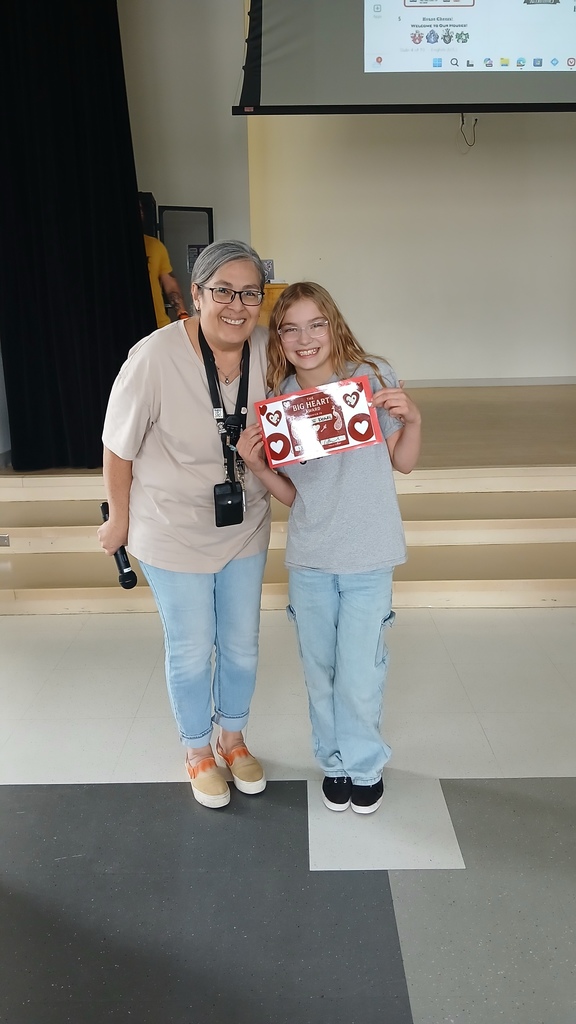 Amidstad house leader Mrs. Nunez posing side by side with Adalee who is holding her red certificate.
