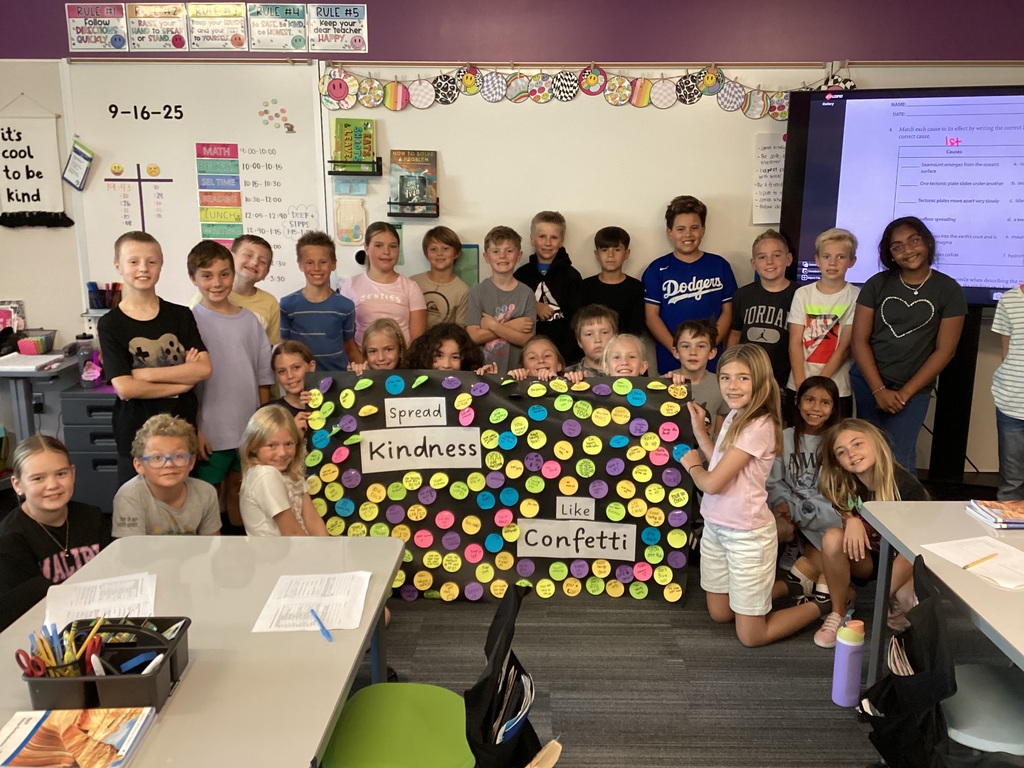 class of 4th graders holding a sign that says Spread Kindness like Confetti