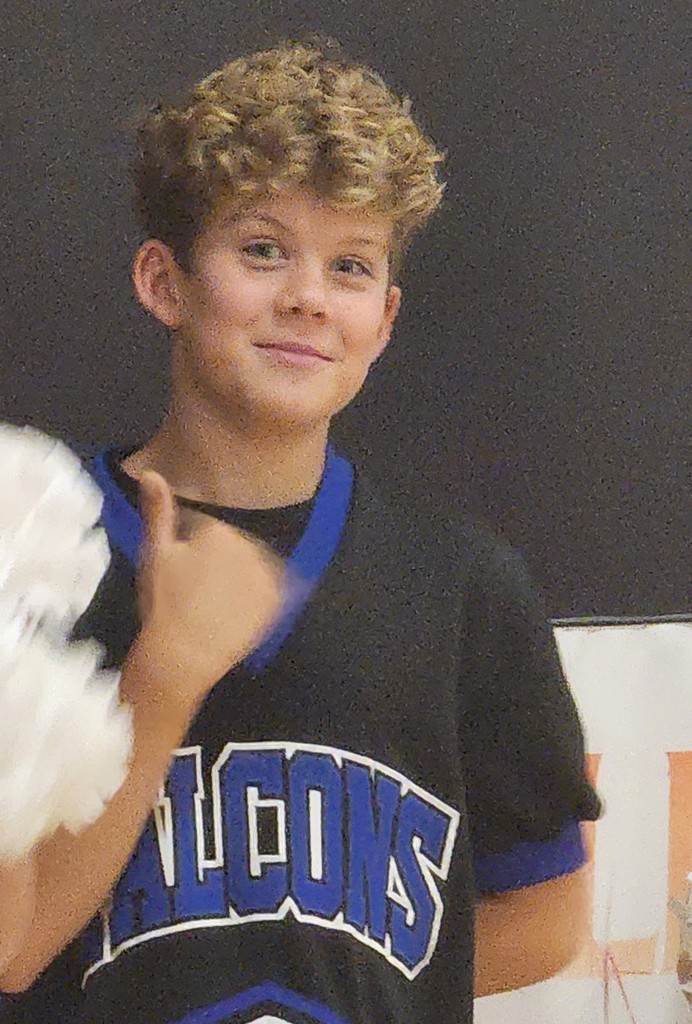 One of Fairfield's cheerleaders with his hand showing a thumbs up gesture, and him smiling.