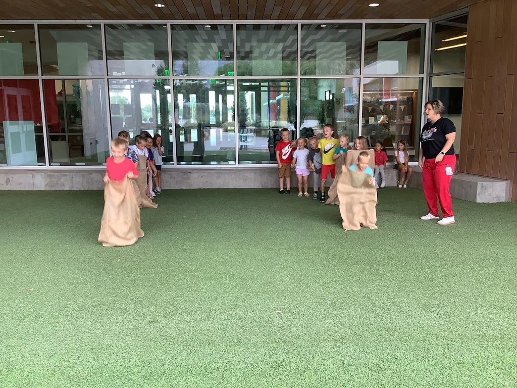 Students in 2 lines competing in a potato sack race