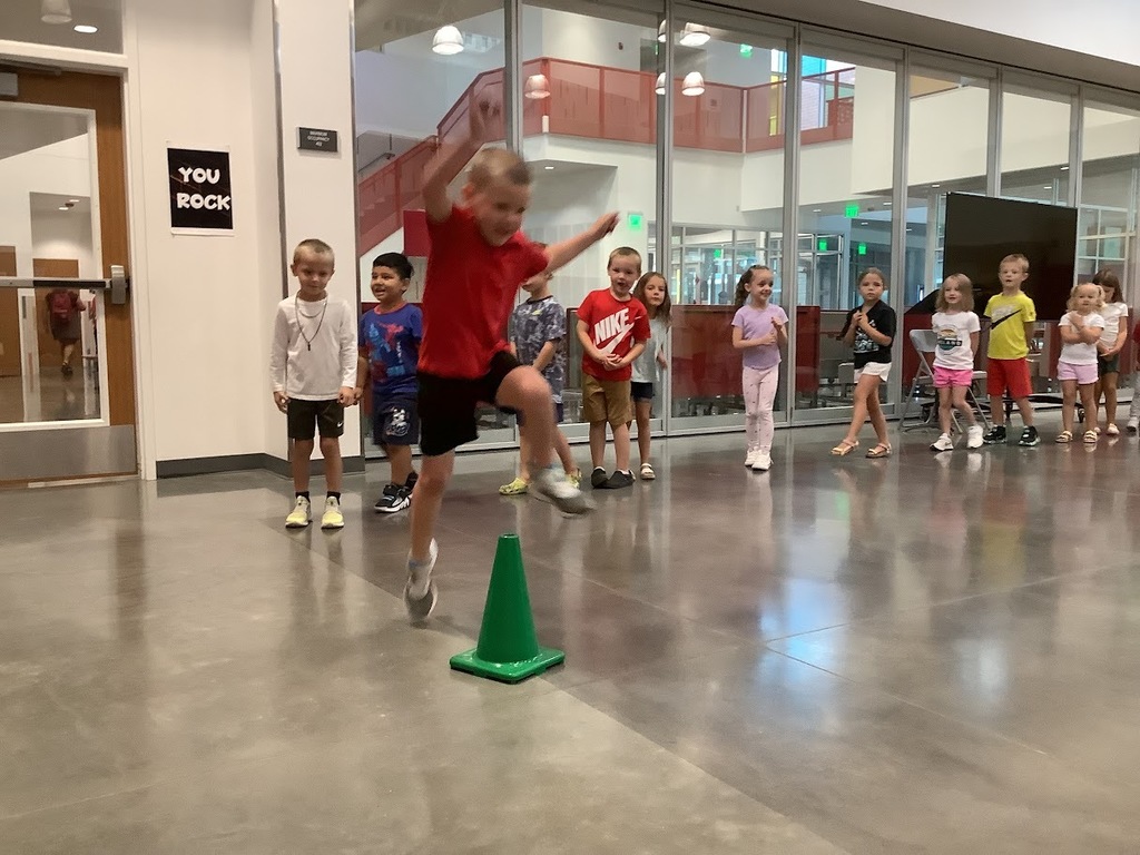 Student jumping over a cone