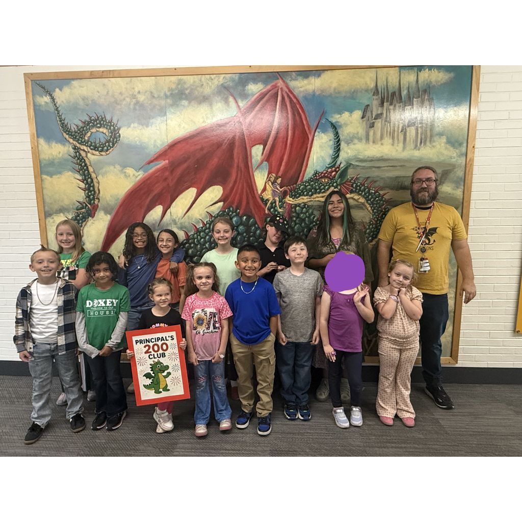 Doxey Elementary students and staff pose for a photo celebrating the Principal's 200 Club in front of the school's dragon mural