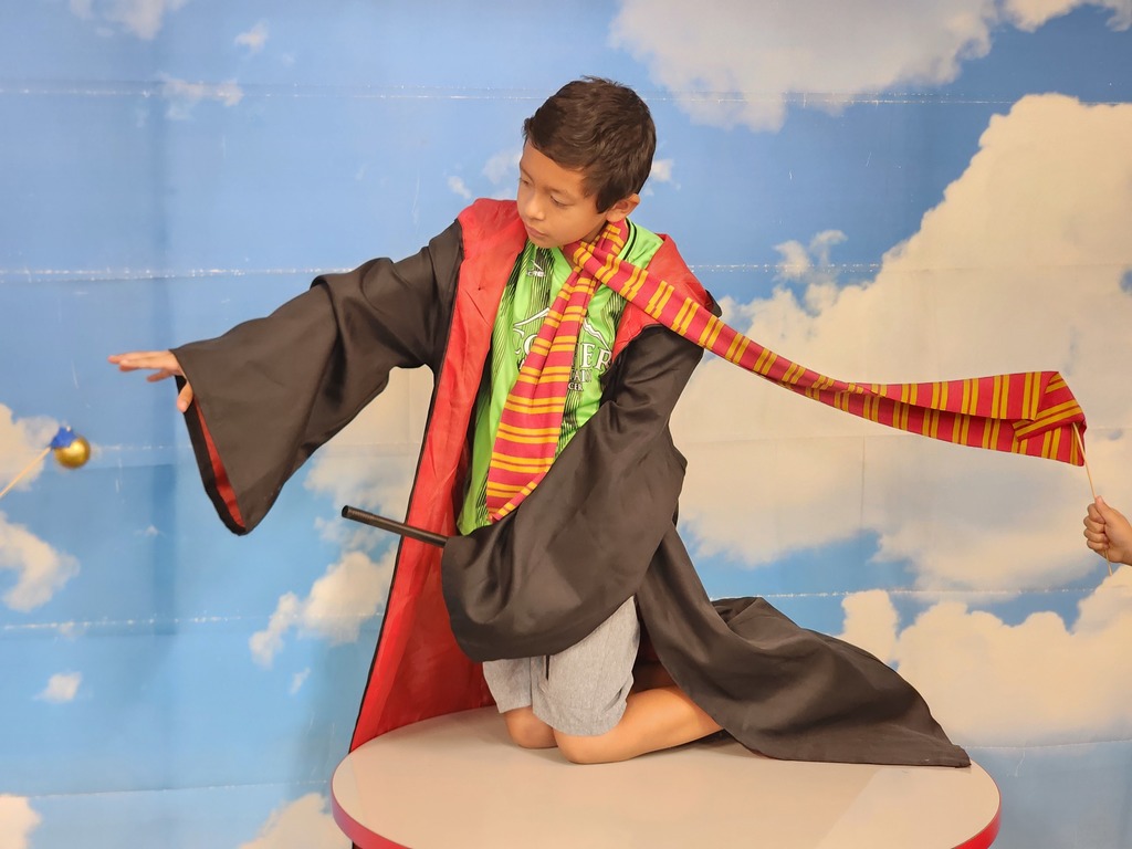 Student dressed as Harry Potter riding a broomstick.
