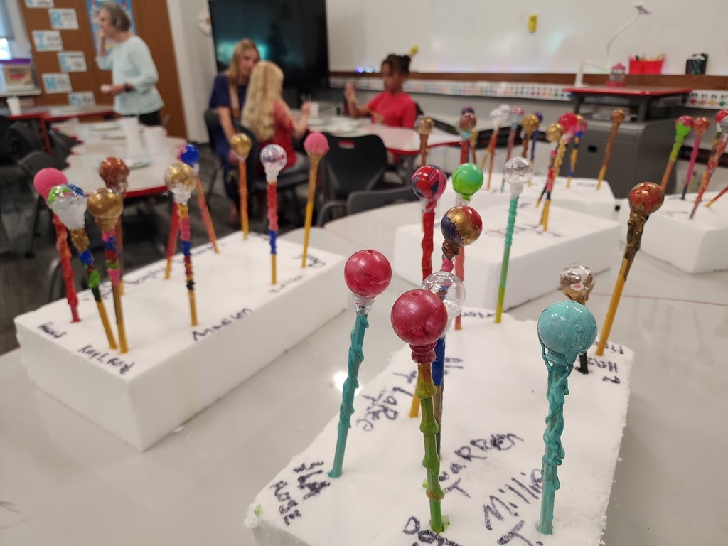 Students wand painting art sitting to dry in classroom.