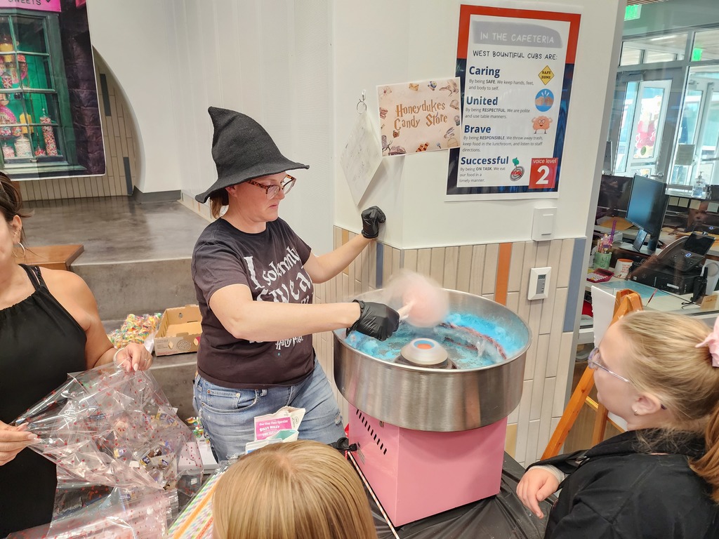 Witch making pink cotton candy for students at the "Honeydukes Candy Store"