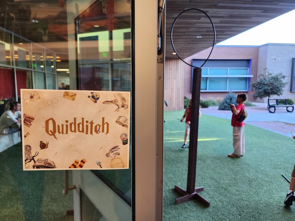 Students playing quidditch in outdoor classroom.