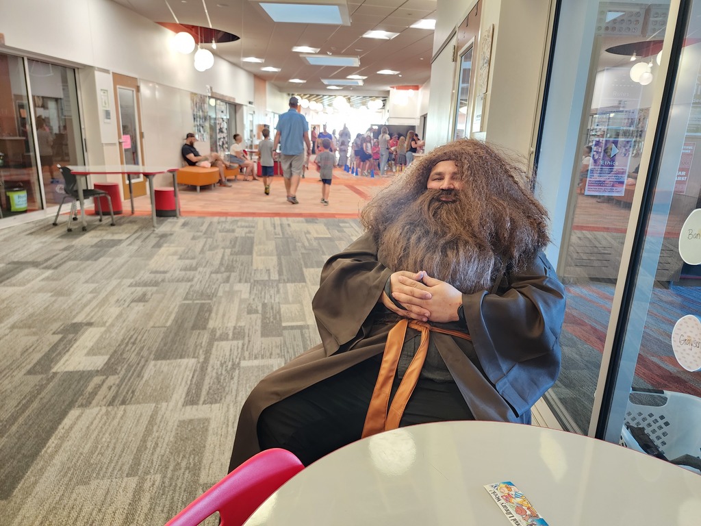 Man dressed as Hagrid from Harry Potter. Sitting in hallway.