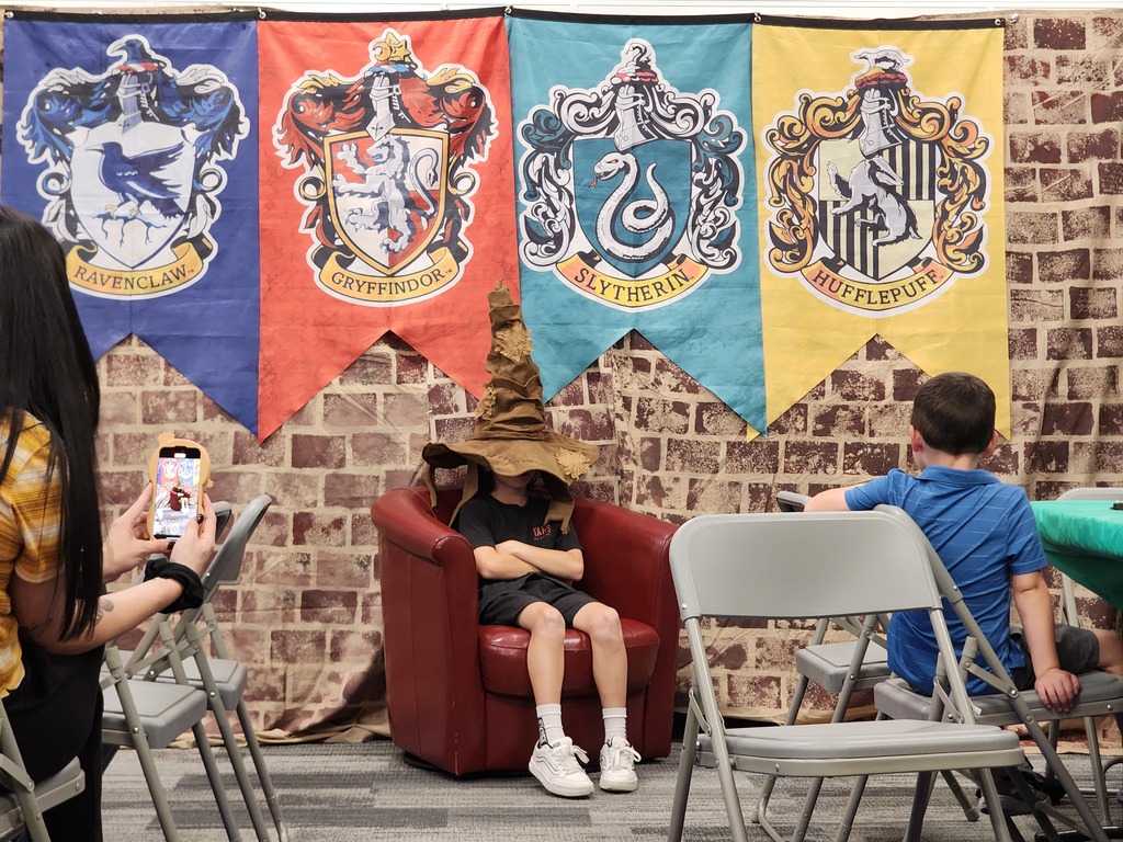 Student sitting in chair wearing the Harry Potter sorting hat.