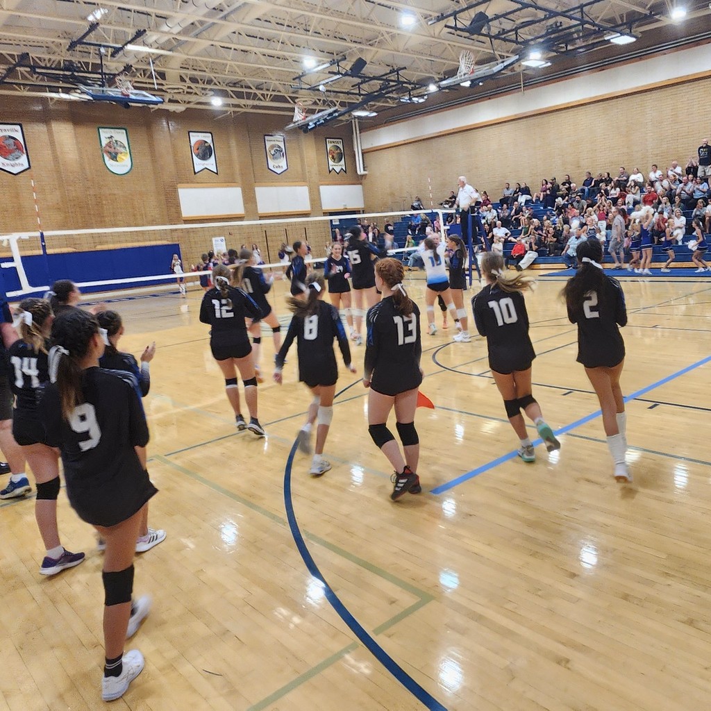 Fairfield players are running onto the court after we just won the game!  The crowd is seated in the bleachers in the background