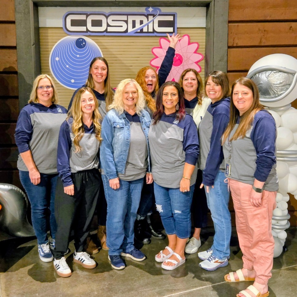 LHS secretaries posing in a "cosmic" balloons backdrop at a secretary conference