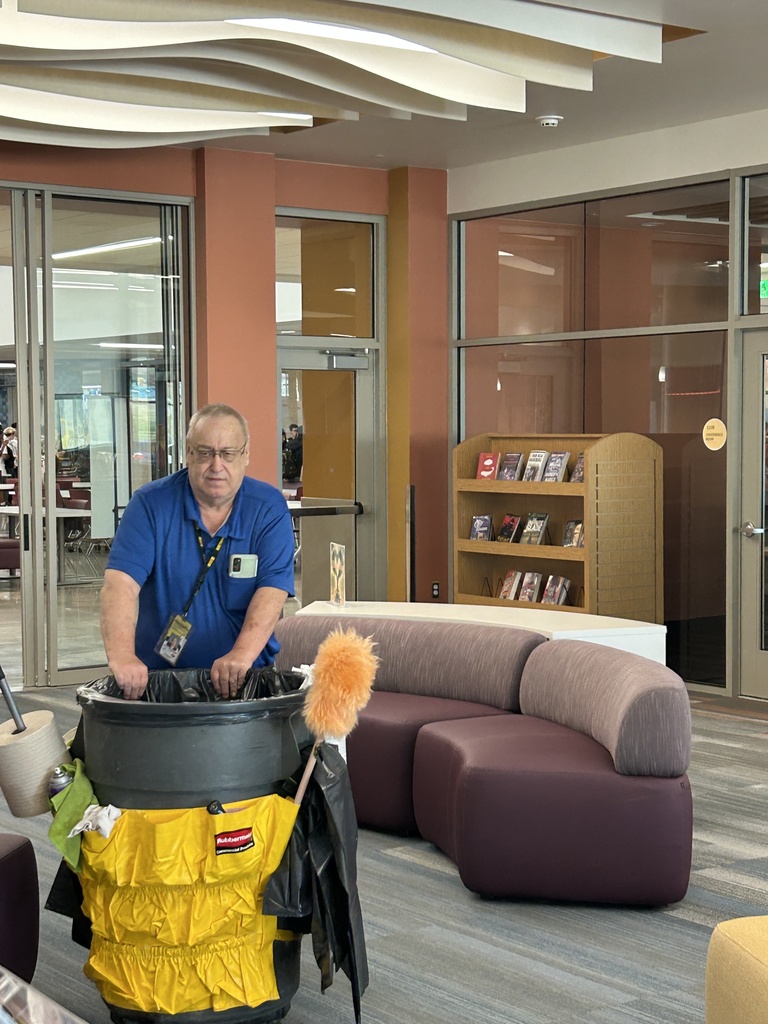 Mr. G. Meacham emptying the trash in the library.