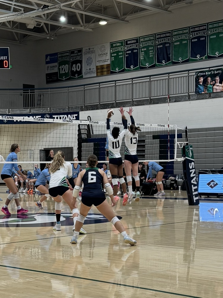 volleyball players jumping to hit the ball