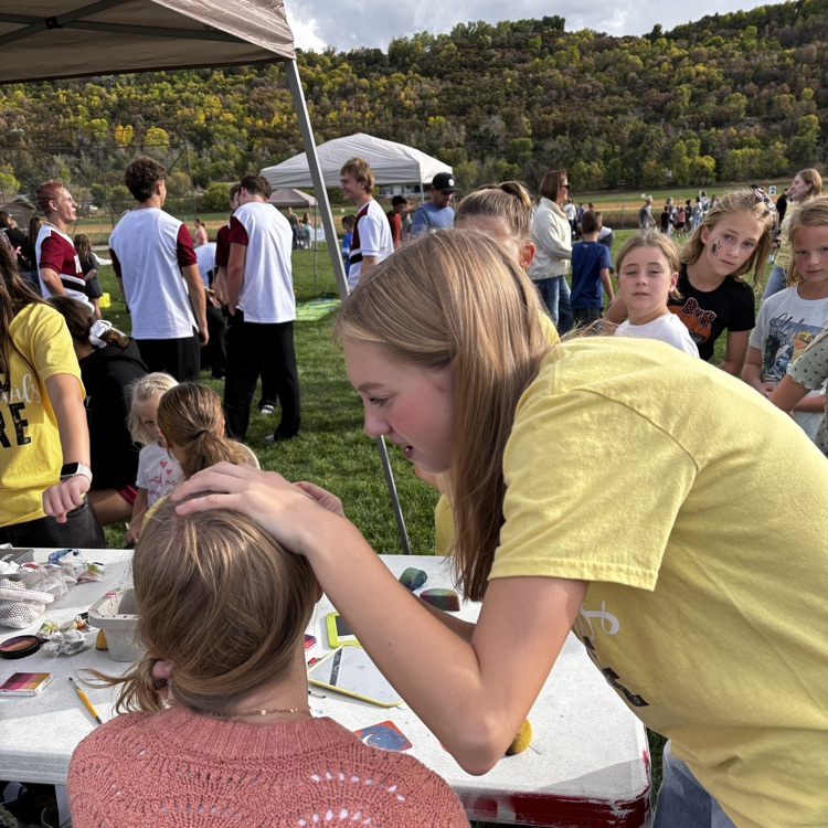 Teenager painting a child’s face