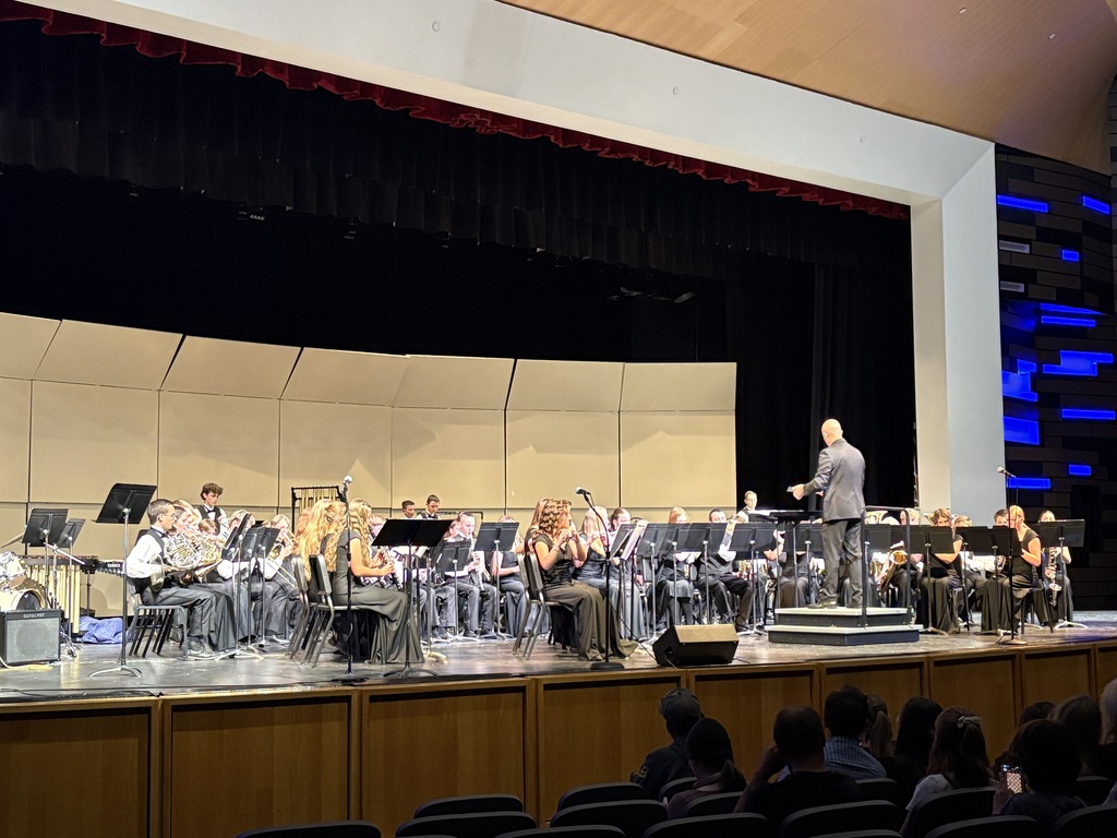 An image of the Millcreek Jr High  bad being conducted by Mr. Frohm. The students are in dress clothes. dresses and vests and ties. 