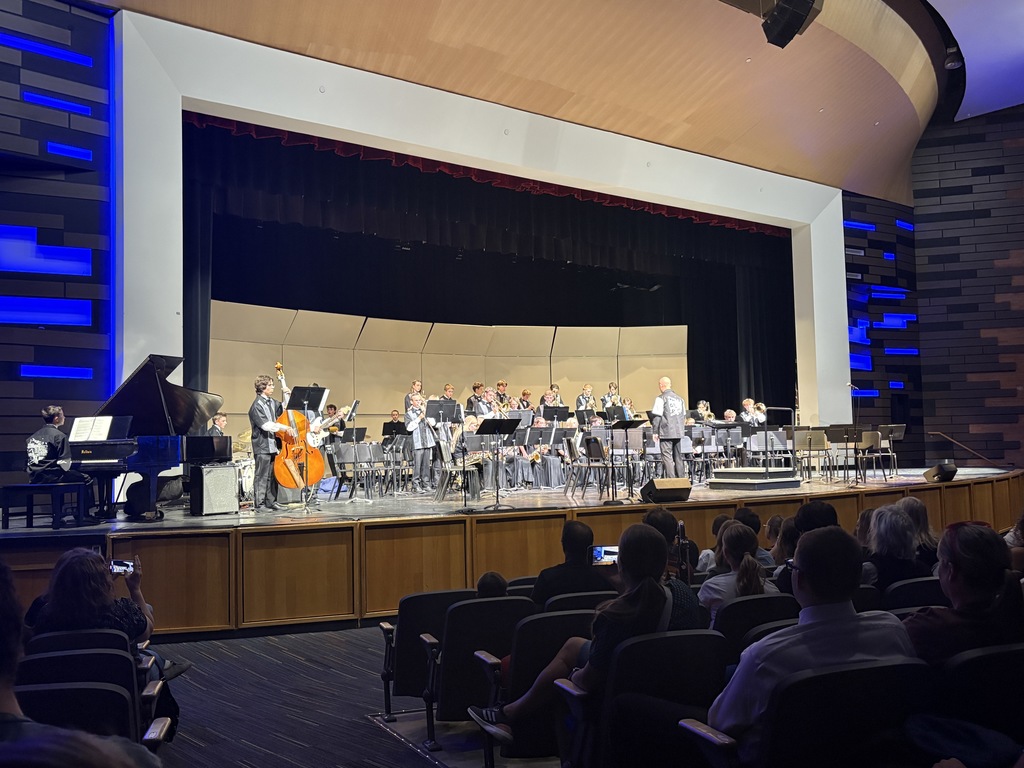 An image of the Millcreek Jr High  bad being conducted by Mr. Frohm. The students are in dress clothes. dresses and vests and ties. 