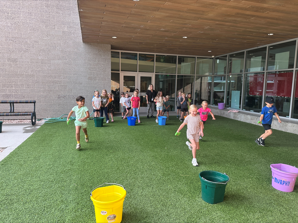 Students racing to water buckets with sponges