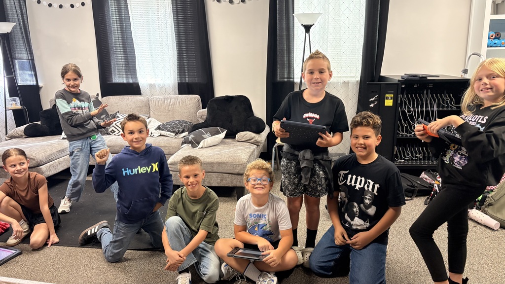 students holding ipads and smiling