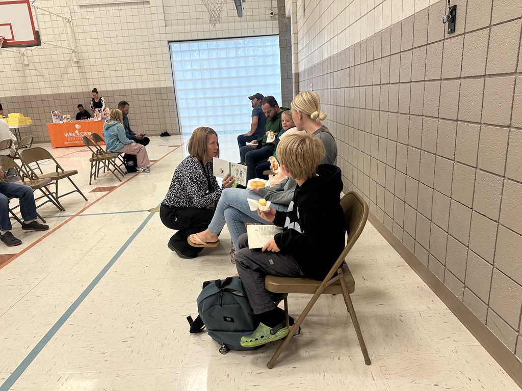 assistant principal reading to students eating a doughnut
