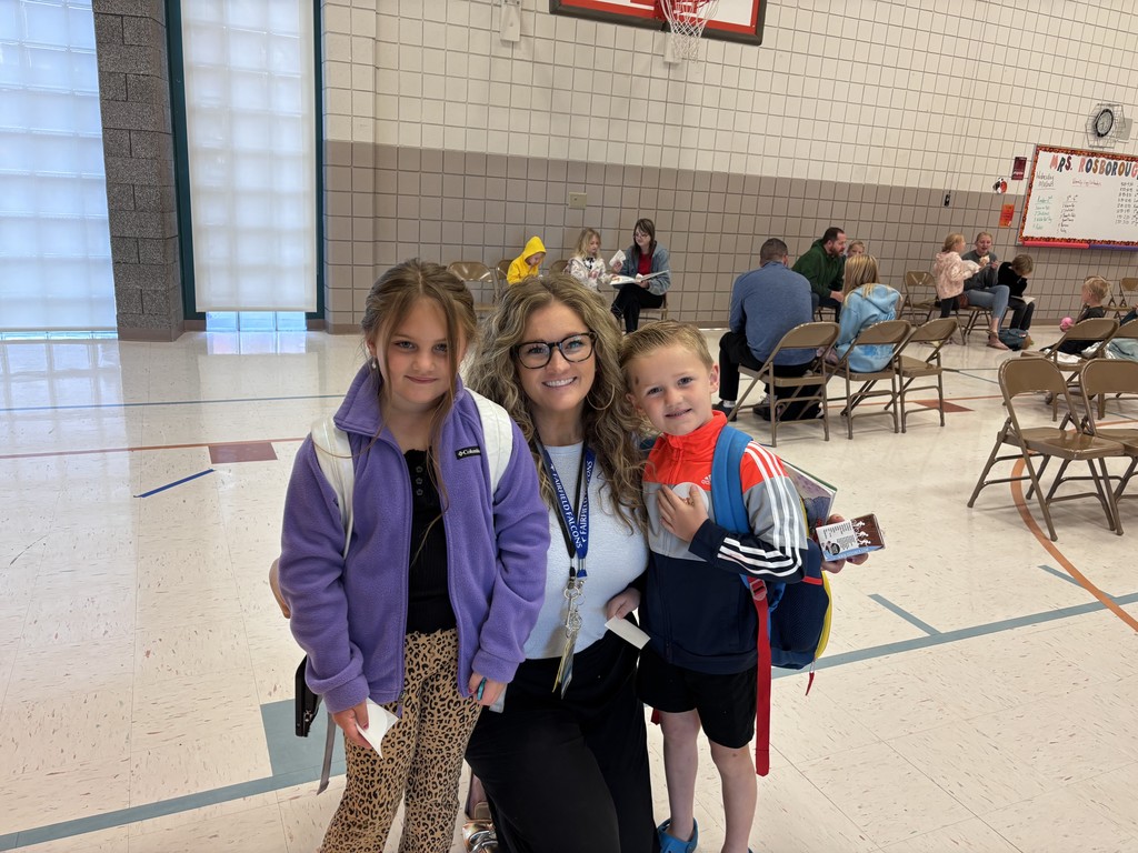 students with mom smiling and others enjoying a doughnut