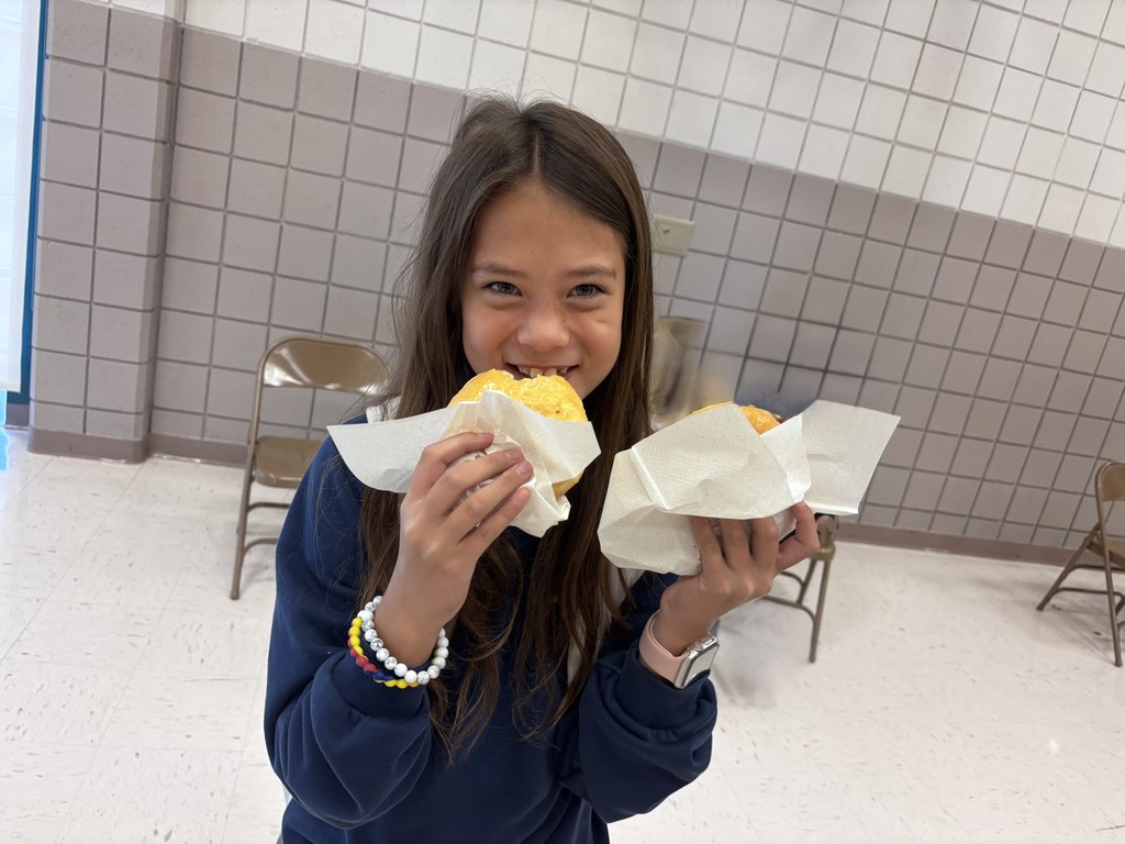 girl smiling and eating a doughnut