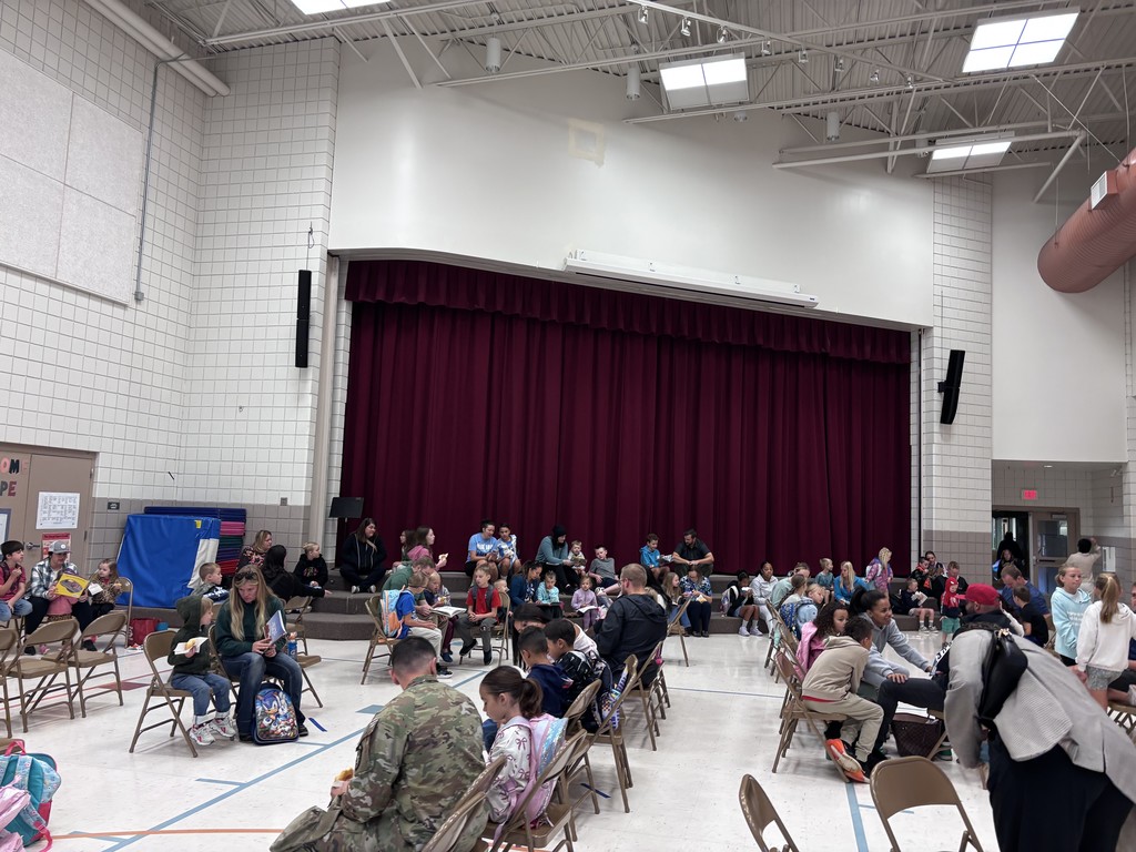 Student and parents sitting in the school gym talking