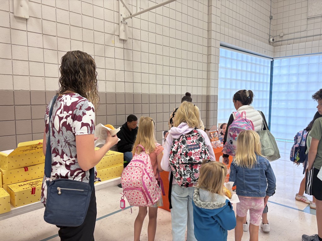 students standing in line for doughnuts in school gym