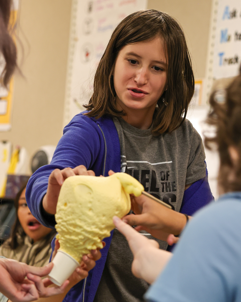 A student touching a hardened foam-like science project.