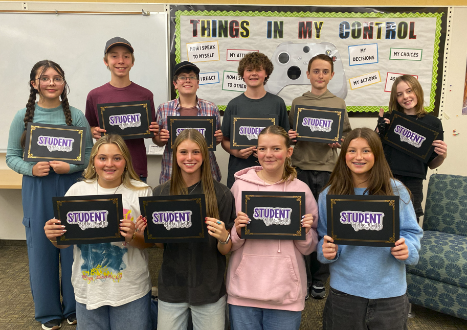 students posing for picture holding certificates for Student of the Month for October