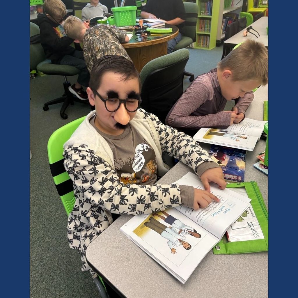 Students in a classroom wearing funny glasses with a big nose and mustache.