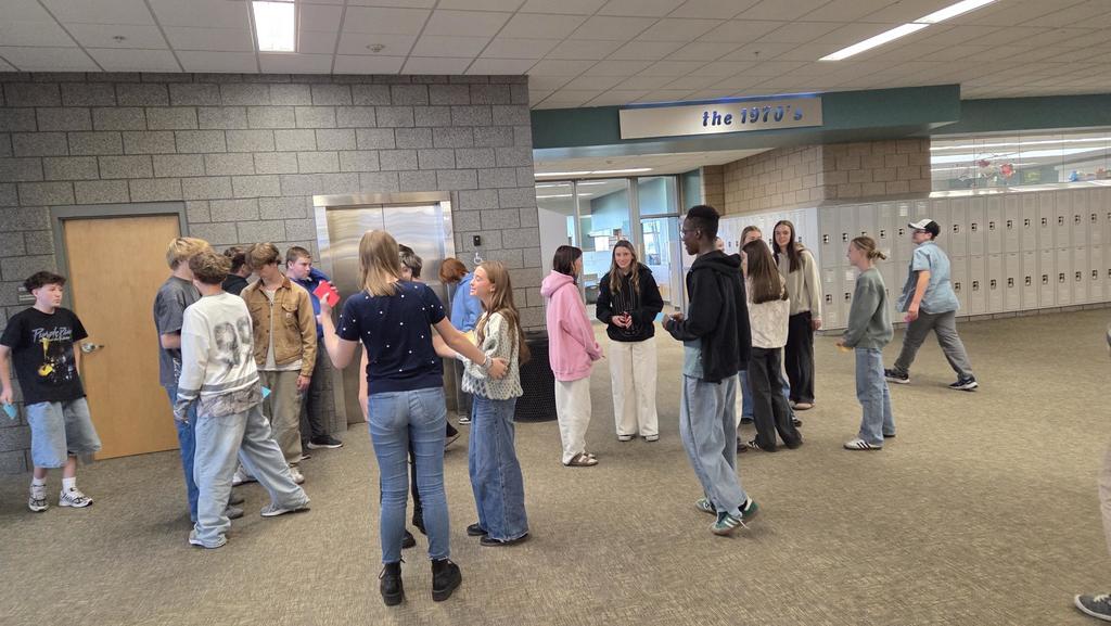 students in a line in the hallway talking