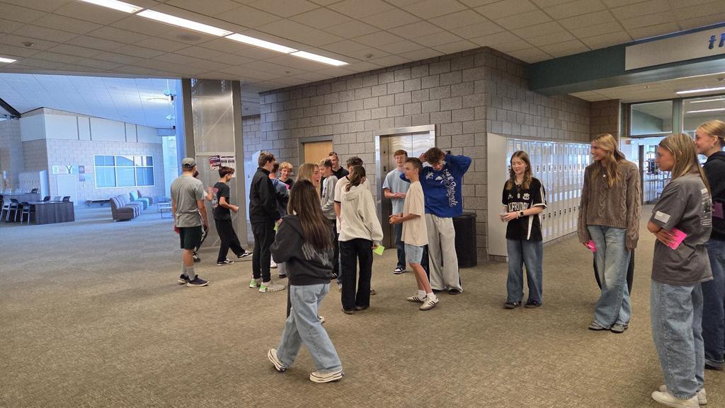 students in a line in the hallway talking