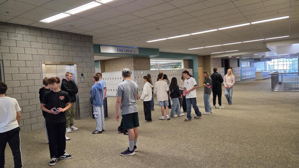 students in a line in the hallway talking