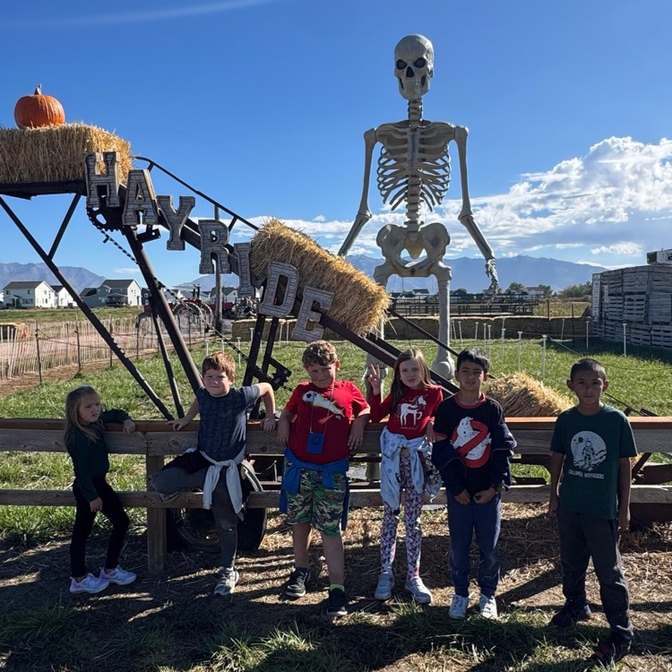 kids waiting in line for hayride next to a 12' skeleton.