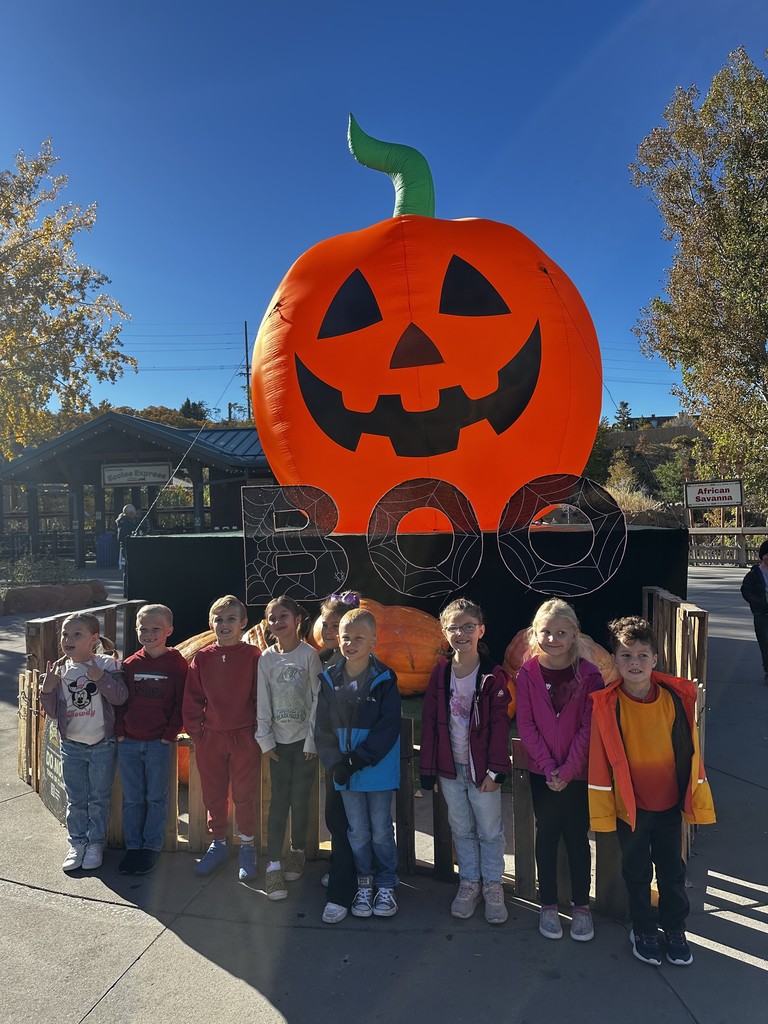 students pictured in front of an inflatable pumpkin and a boo sign