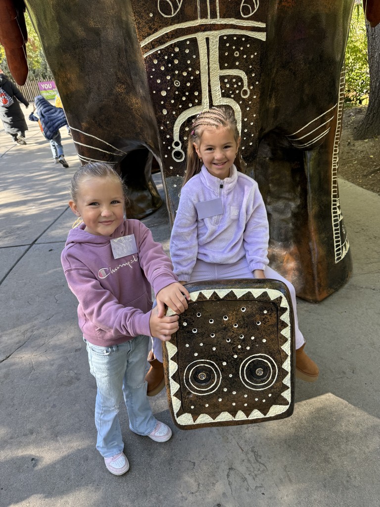 students pictured on an elephant statue at the zoo
