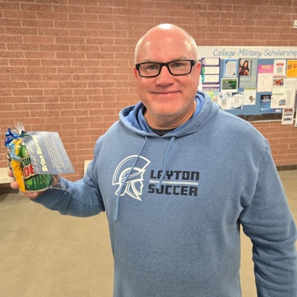 Coach Berrong holding his Bright Spot Award